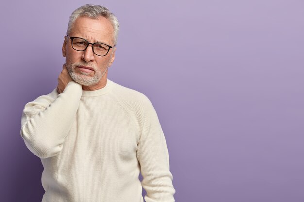 Старший мужчина в белом свитере и очках