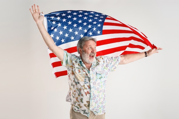 アメリカ合衆国の旗を持つシニア男性