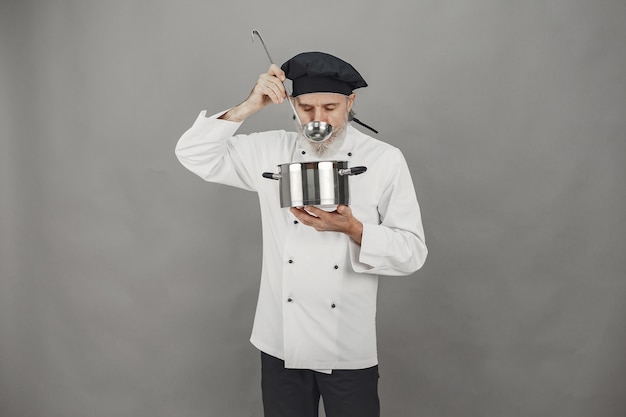 Free photo senior man with metal pan. chef in a black hat. professional approach to business.