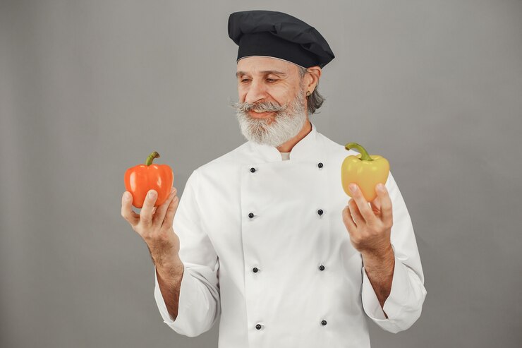 Free Photo senior man with red and yellow peper. professional approach to business.