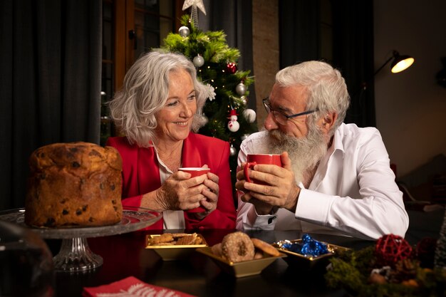 Старший мужчина и женщина празднуют Рождество