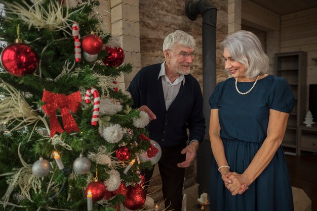 Senior man and woman next to the christmas tree