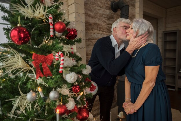 Senior man and woman next to the christmas tree