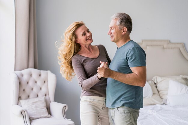 Senior man and woman holding hands and smiling