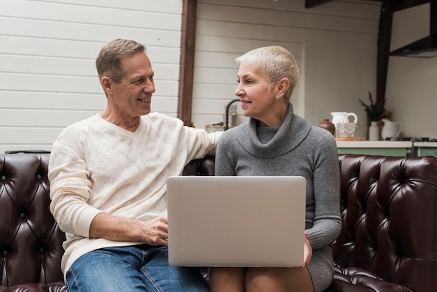 Free photo senior man and woman looking through their laptop