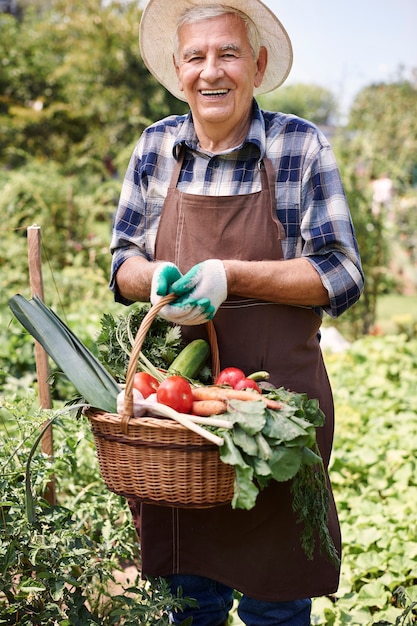 Старший мужчина, работающий в поле с овощами