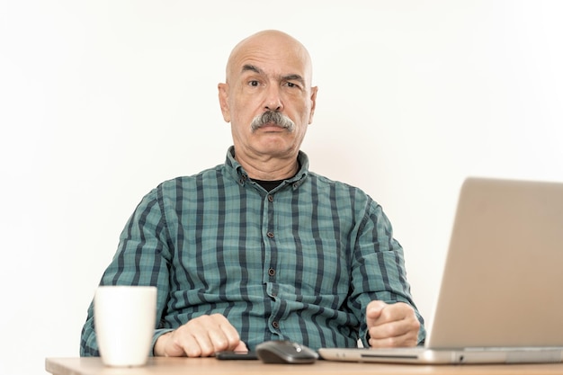 Старший мужчина, работающий с ноутбуком дома
