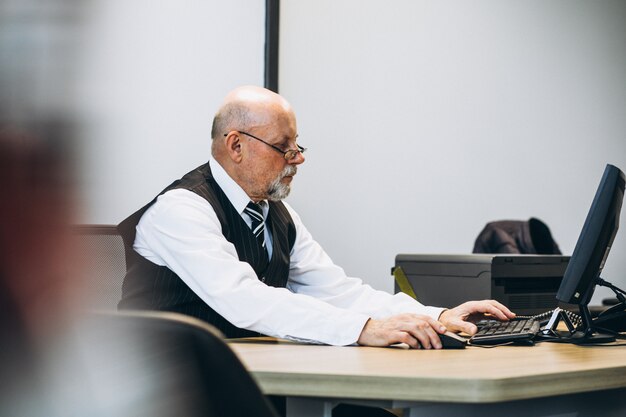 Senior manager at the office working on a computer