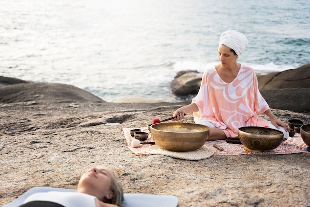 Senior meditation guide with singing bowls