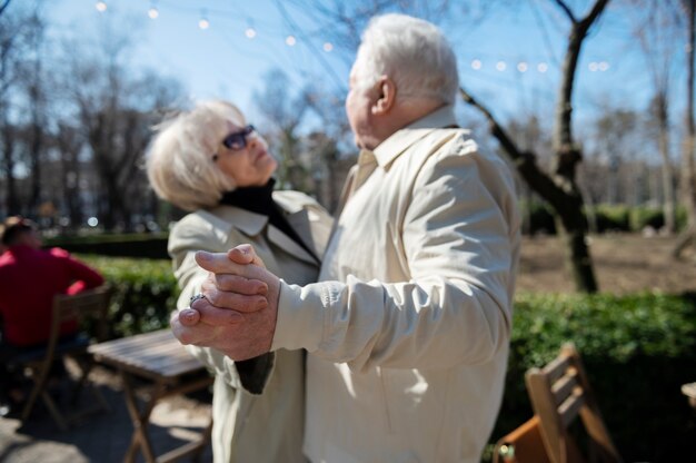 Senior people dancing in park medium shot