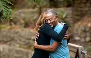 Free photo senior people hugging outdoors medium shot