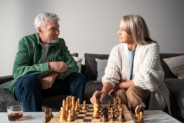 Старшие люди играют в шахматы средний выстрел