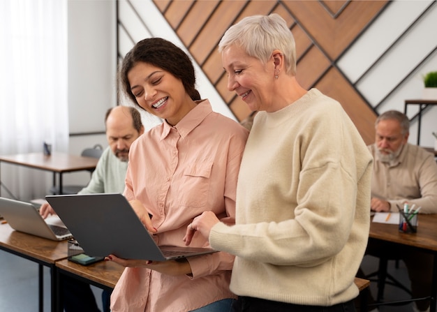 Foto gratuita persone anziane a scuola durante le lezioni con il computer portatile