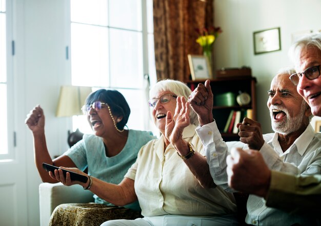 Senior people watching televison together