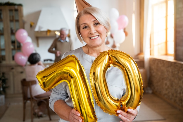 Senior person celebrationg with balloons