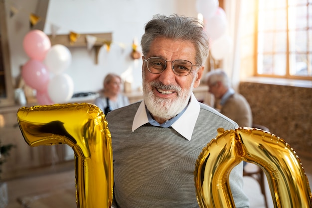 Senior person celebrationg with balloons