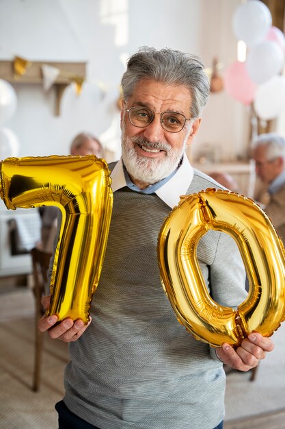 Senior person celebrationg with balloons