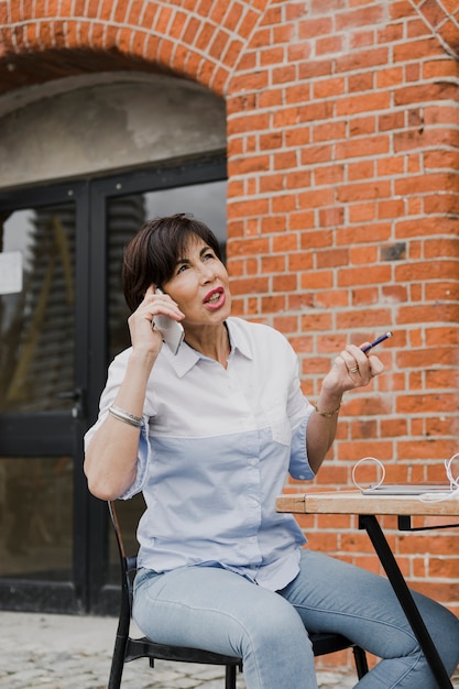 Senior sitting outdoors with the phone