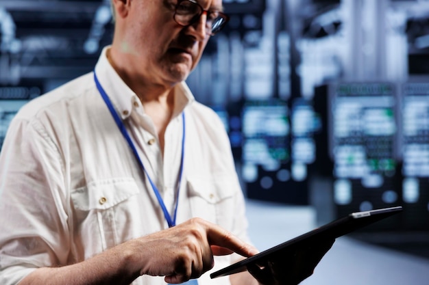 Free photo senior supervisor inspects operational server rigs in computer network security data center, ensuring errorless performance. trained expert monitoring energy consumption across hardware parts