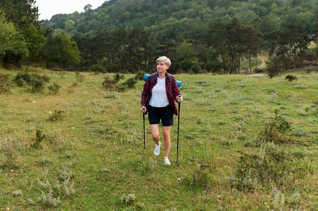 Senior tourist woman outdoors with backpack