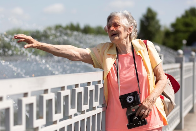 Foto gratuita viaggiatore anziano con in mano una macchina fotografica