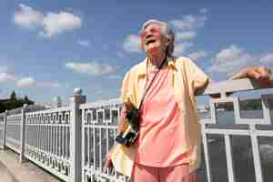 Free photo senior traveler holding a camera