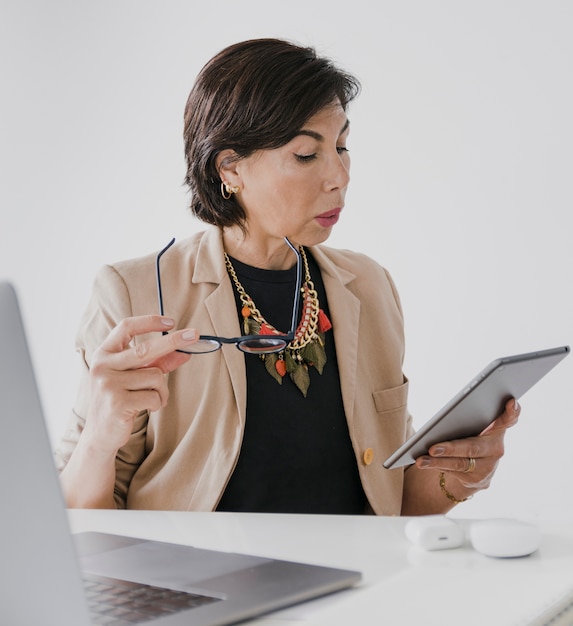 Free photo senior with necklace holding a tablet