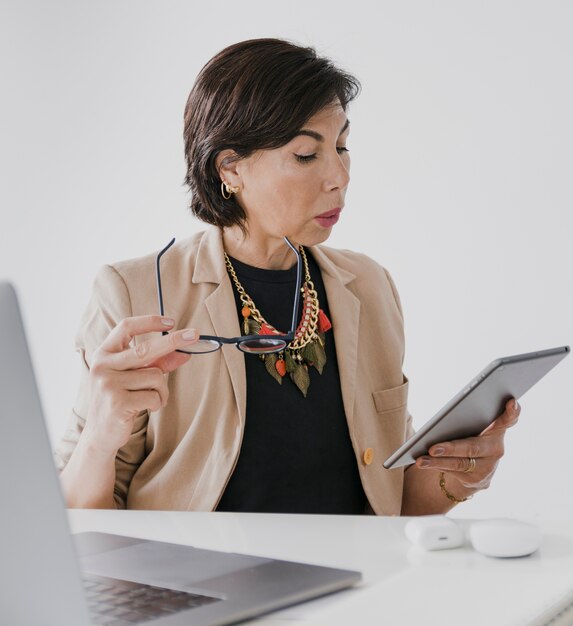 Senior with necklace holding a tablet