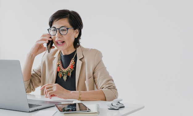 Free photo senior with necklace talking on the phone with copyspace