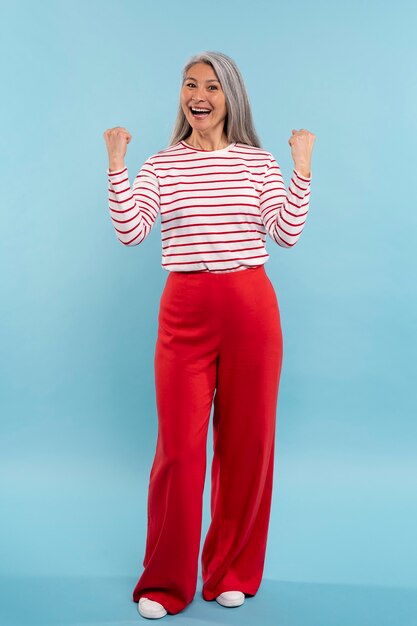 Senior woman being excited against a blue background