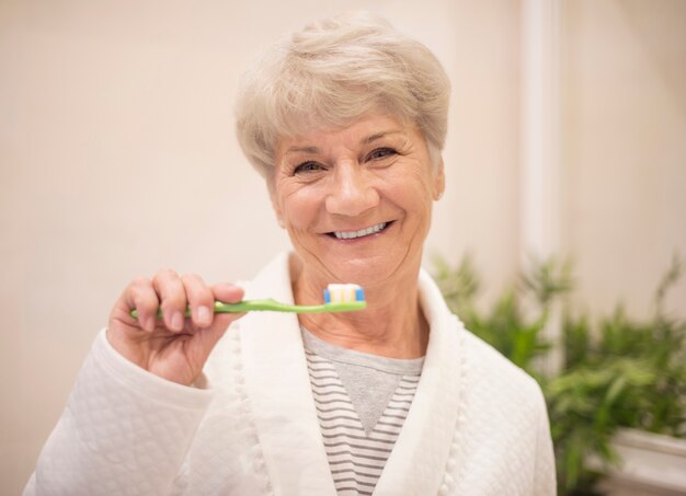 Senior woman brushing her teeth
