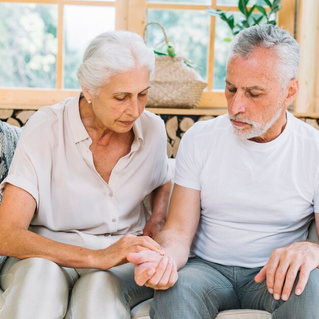 Senior woman checking pulse of her husband