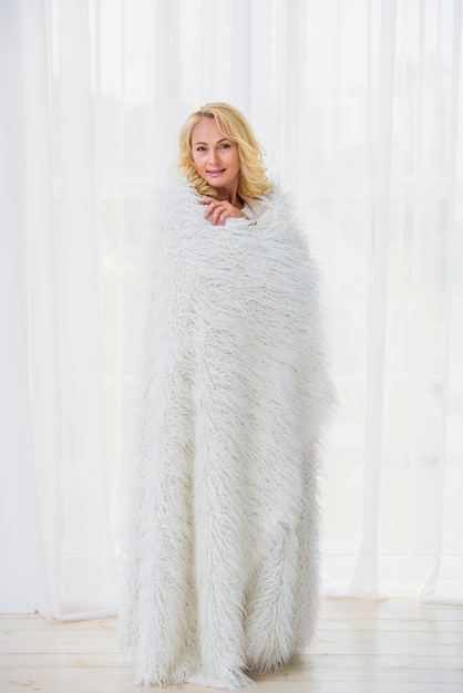 Free photo senior woman covering herself with a fluffy blanket
