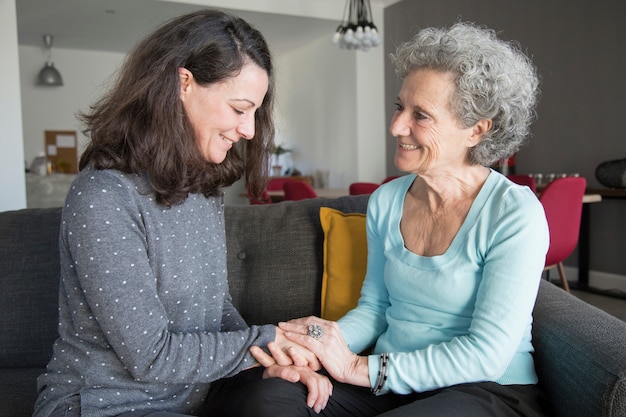 Senior woman and daughter chatting at home