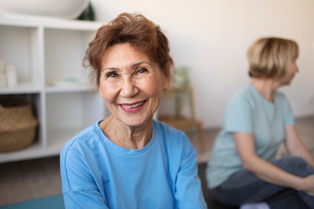 Senior woman doing exercises at home and spending time with friends