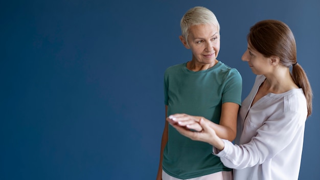 Free photo senior woman doing an occupational therapy session with a psychologist with copy space