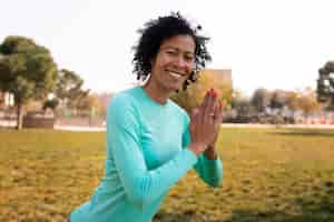 Free photo senior woman doing yoga outdoors in the park