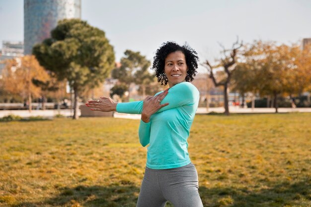 Foto gratuita donna maggiore che fa yoga all'aperto nel parco