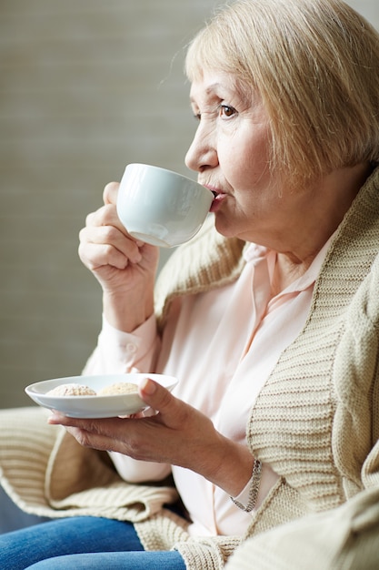 カフェでコーヒーを飲む年配の女性