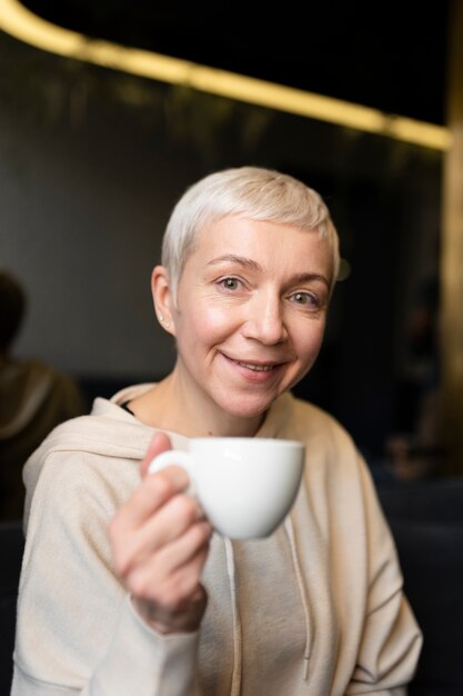 Senior woman drinking coffee during a gathering