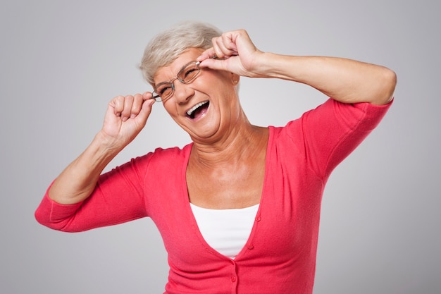 Senior woman has fun with fashion glasses