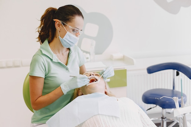 Senior woman having dental treatment at dentist's office. Woman is being treated for teeth