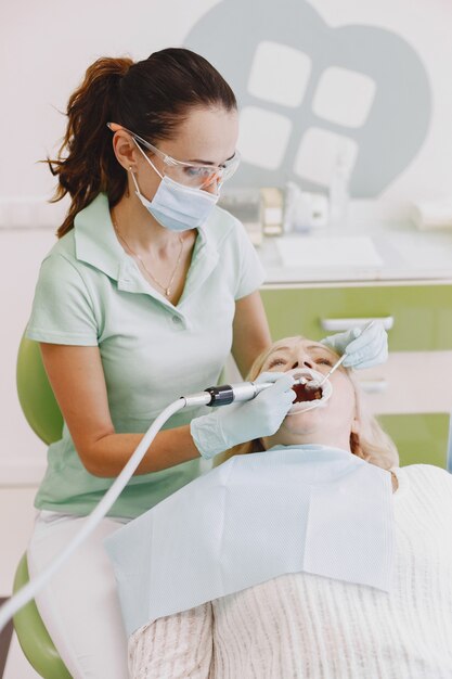 Senior woman having dental treatment at dentist's office. Woman is being treated for teeth