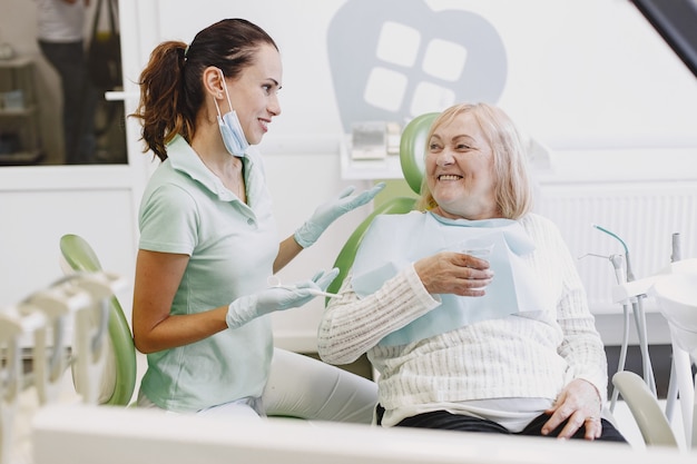 歯科医院で歯科治療を受けている年配の女性。女性は歯の治療を受けています