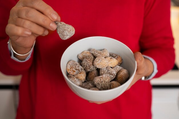 Senior woman having fig fruits at home