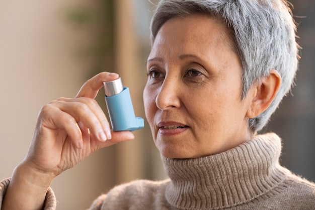 Senior woman holding asthma inhaler
