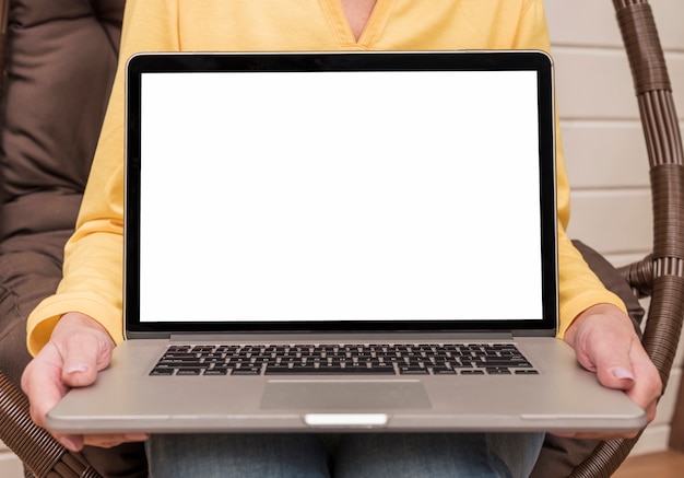 Free photo senior woman holding an empty laptop