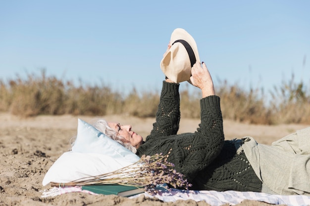 Free photo senior woman holding fedora hat