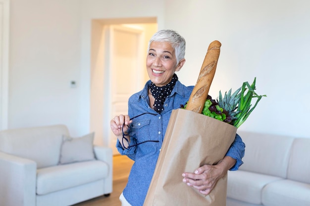 Foto gratuita donna anziana che tiene un sacchetto di carta pieno di generi alimentari che urla orgoglioso e celebra la vittoria e il successo emozione incoraggiante molto eccitata