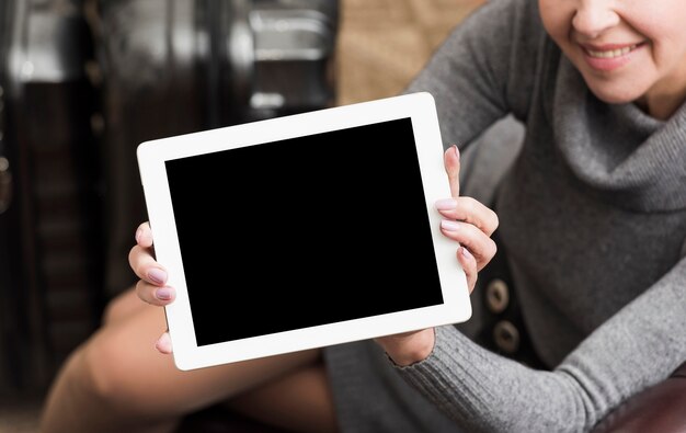 Senior woman holding up an empty tablet